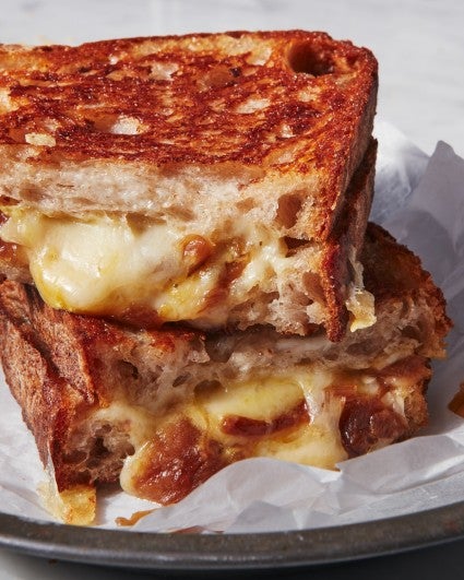 French onion grilled cheese sandwich cut in quarters, two pieces stacked on a plate